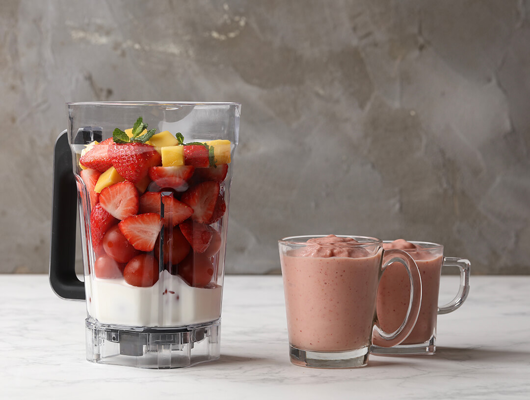 A blender with strawberry smoothie